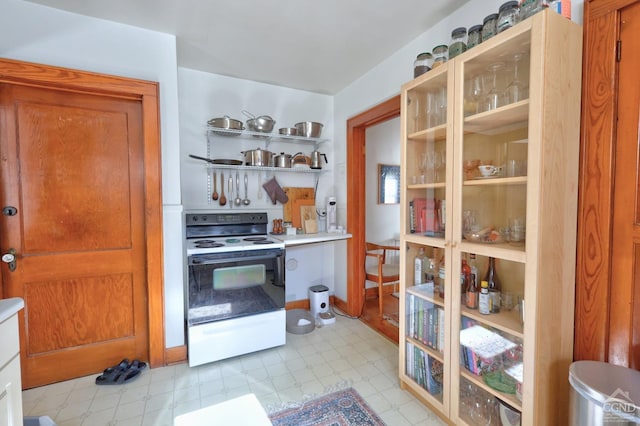 825 Union St, Hudson, NY 12534 - kitchen featuring range with electric cooktop, light floors, light countertops, brown cabinets, and open shelves