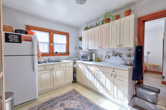825 Union St, Hudson, NY 12534 - kitchen featuring freestanding refrigerator, light countertops, radiator, and a sink