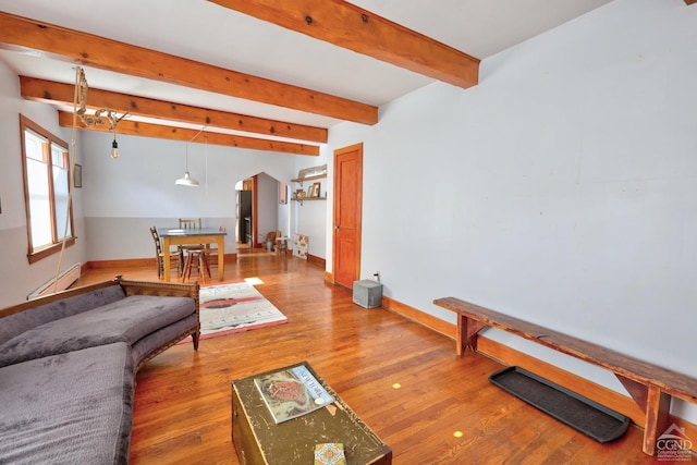 825 Union St, Hudson, NY 12534 - living area featuring baseboards, wood finished floors, beamed ceiling, a baseboard heating unit, and arched walkways