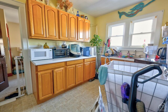 825 Union St, Hudson, NY 12534 - kitchen featuring white microwave, brown cabinetry, light countertops, and light tile patterned flooring