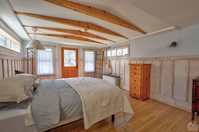 825 Union St, Hudson, NY 12534 - bedroom with light wood finished floors, radiator, a wainscoted wall, vaulted ceiling, and a decorative wall