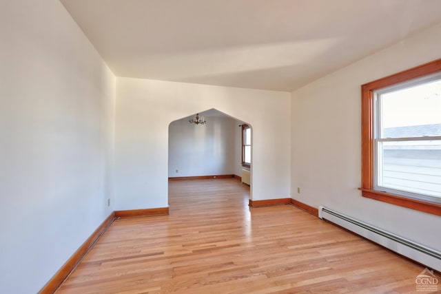 825 Union St, Hudson, NY 12534 - unfurnished room featuring a baseboard radiator, arched walkways, light wood-style floors, and baseboards