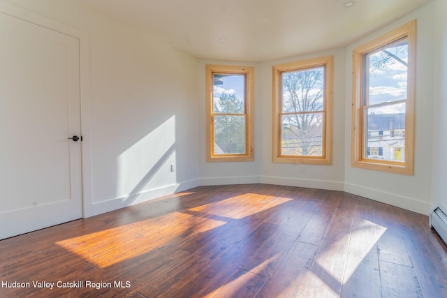 empty room with hardwood / wood-style flooring, baseboards, and a wealth of natural light