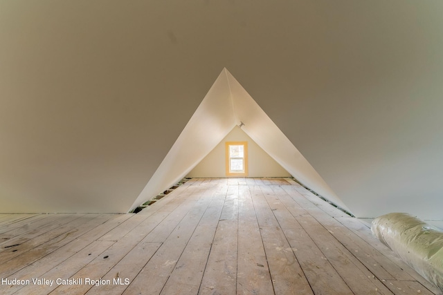 additional living space featuring vaulted ceiling and hardwood / wood-style flooring