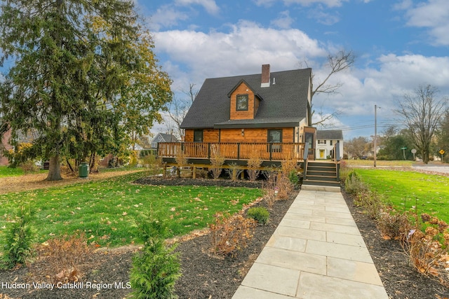 view of front of property featuring a deck, a chimney, and a front lawn