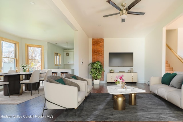 living room with stairs, ceiling fan, hardwood / wood-style floors, and baseboards