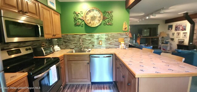 56 Highlands Dr Unit F3, Hunter, NY 12442 - kitchen featuring appliances with stainless steel finishes, a peninsula, tasteful backsplash, rail lighting, and open floor plan