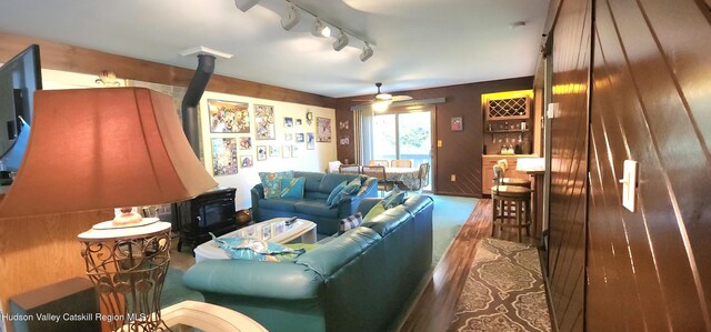 56 Highlands Dr Unit F3, Hunter, NY 12442 - living room with a wood stove, a bar, rail lighting, and a ceiling fan