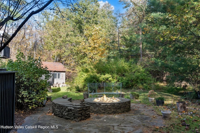 view of patio / terrace featuring a fire pit and an outdoor structure