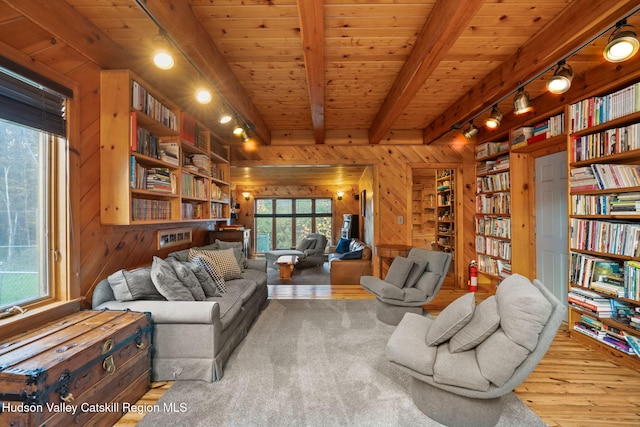 living room with wood walls, track lighting, beamed ceiling, wood-type flooring, and wood ceiling