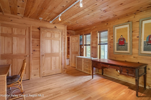 unfurnished office featuring light wood-type flooring, rail lighting, wood walls, and wood ceiling