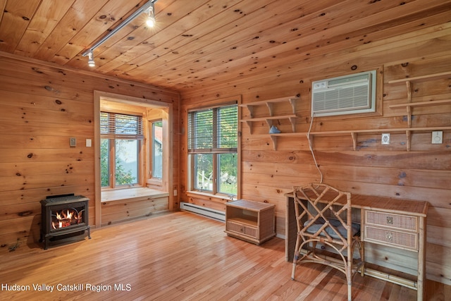 interior space featuring wood walls, a wood stove, wooden ceiling, hardwood / wood-style flooring, and a baseboard radiator