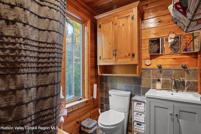 bathroom with wood walls, toilet, decorative backsplash, vanity, and wood ceiling