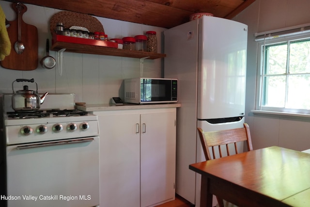 3 Dymond Rd, Kerhonkson, NY 12446 - kitchen with black microwave, white gas stove, open shelves, light countertops, and white cabinetry