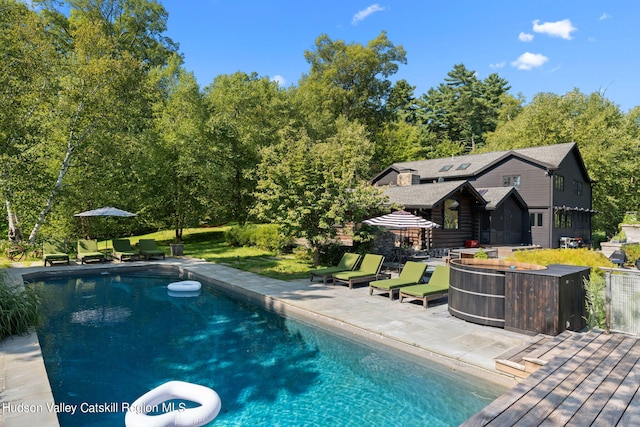 view of swimming pool with a deck and a patio