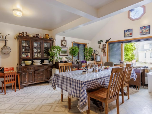 dining space featuring light floors and lofted ceiling