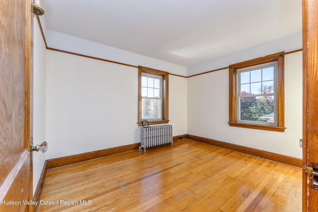 empty room with radiator heating unit and light wood-type flooring