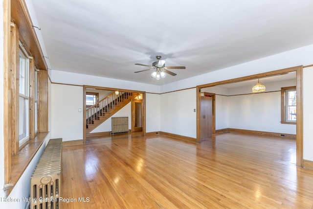 unfurnished room featuring radiator heating unit, a healthy amount of sunlight, and light hardwood / wood-style floors