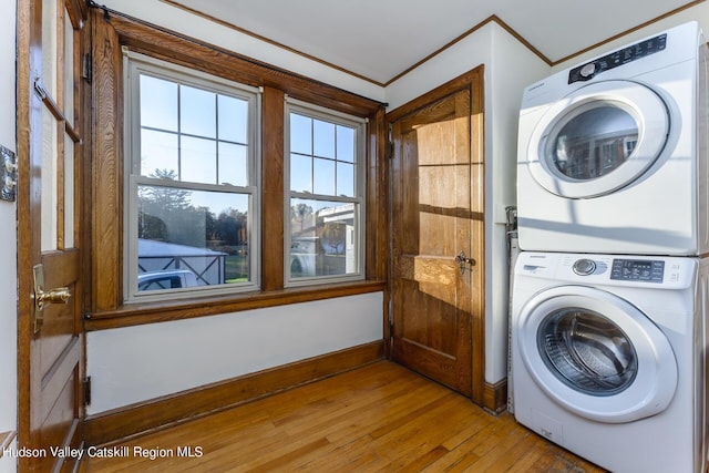 washroom with hardwood / wood-style floors and stacked washer / dryer