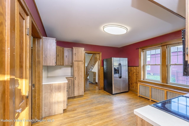 kitchen featuring stainless steel fridge, light hardwood / wood-style flooring, and radiator heating unit