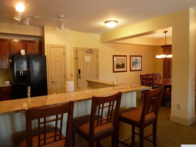 62 Liftside Dr Unit 432K4, Hunter, NY 12442 - kitchen with black refrigerator with ice dispenser, light stone countertops, a breakfast bar, and backsplash