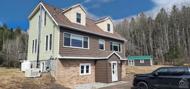 273 E Conesville Rd, Conesville, NY 12076 - view of front of property featuring brick siding, a shingled roof, and a wooded view