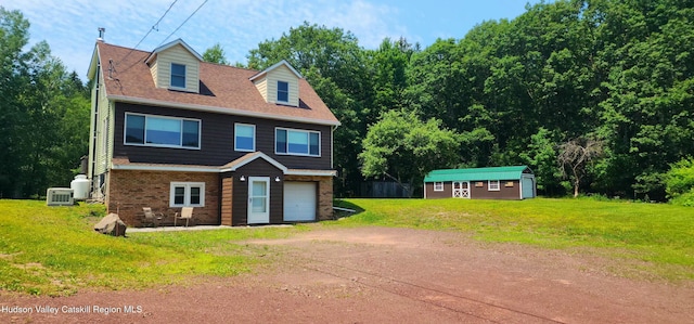 273 E Conesville Rd, Conesville, NY 12076 - view of front of property with dirt driveway, a front lawn, a garage, brick siding, and an outdoor structure