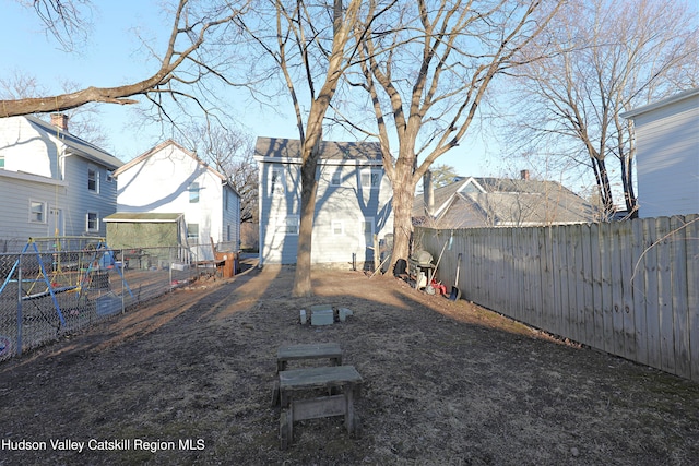 view of yard with a fenced backyard and an outbuilding