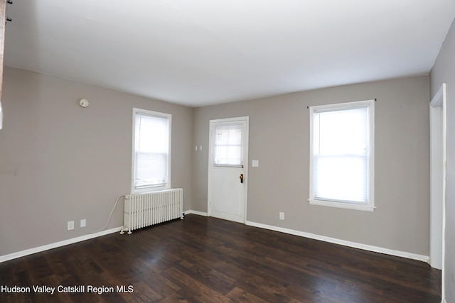 entryway with radiator, wood finished floors, and baseboards