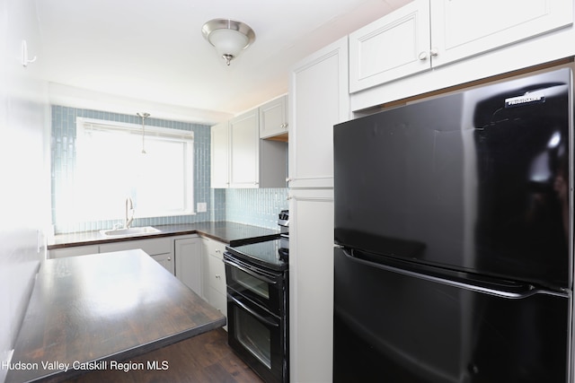 kitchen featuring tasteful backsplash, white cabinets, black appliances, a sink, and dark wood-style floors