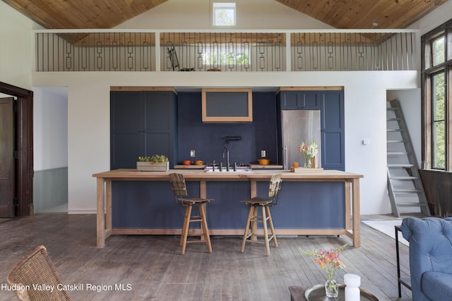 150 Blenheim Hill Rd, Jefferson, NY 12093 - kitchen featuring stainless steel refrigerator, blue cabinets, high vaulted ceiling, a kitchen bar, and plenty of natural light
