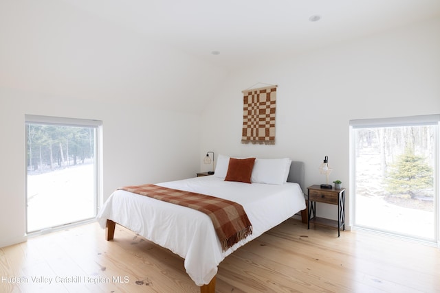 bedroom featuring access to outside, lofted ceiling, and light wood finished floors