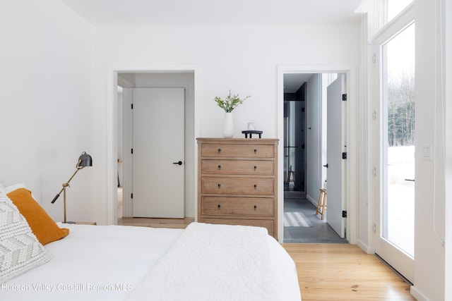 bedroom with access to outside and light wood-type flooring