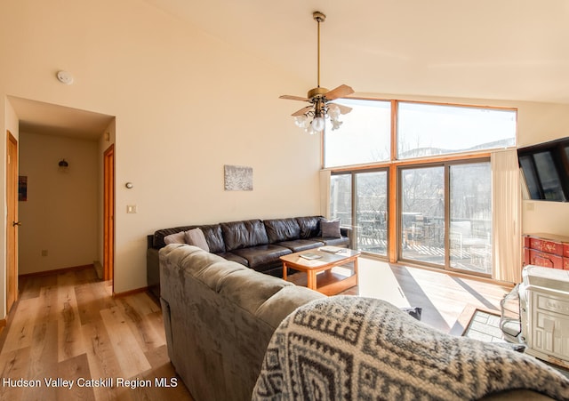 living room featuring high vaulted ceiling, light hardwood / wood-style flooring, and ceiling fan