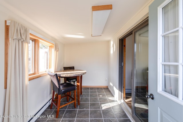 tiled dining room featuring a baseboard heating unit