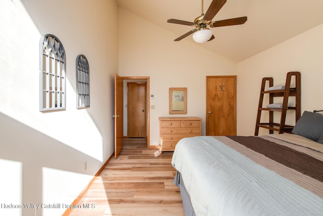 bedroom featuring ceiling fan, light wood-type flooring, and high vaulted ceiling