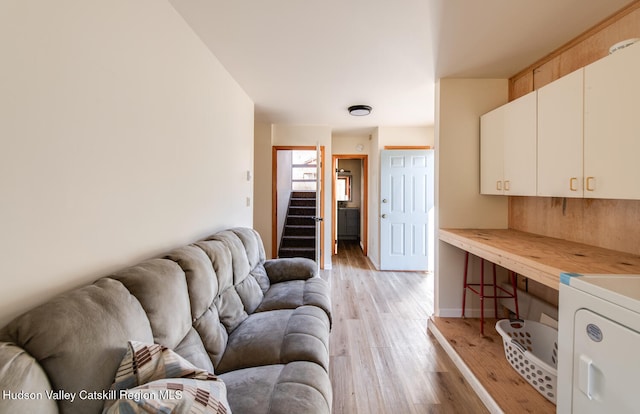 living room with washer / clothes dryer and light hardwood / wood-style flooring