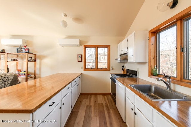 kitchen with a wealth of natural light, sink, white cabinets, and a wall mounted air conditioner