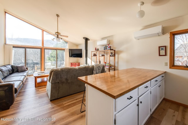 kitchen featuring white cabinets, light hardwood / wood-style floors, and a wall mounted air conditioner