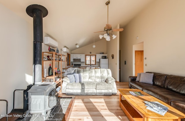 living room with hardwood / wood-style floors, a wood stove, high vaulted ceiling, an AC wall unit, and ceiling fan