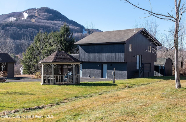 exterior space featuring a mountain view, a sunroom, and a lawn