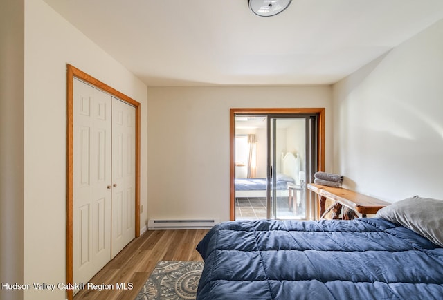 bedroom with a baseboard radiator and hardwood / wood-style flooring