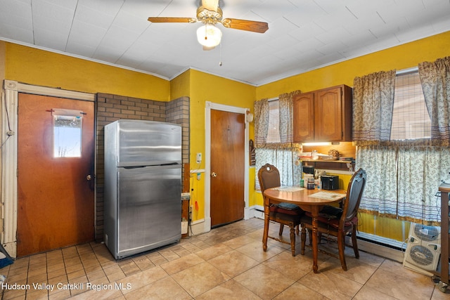 kitchen with light tile patterned floors, stainless steel fridge, ceiling fan, ornamental molding, and a baseboard radiator