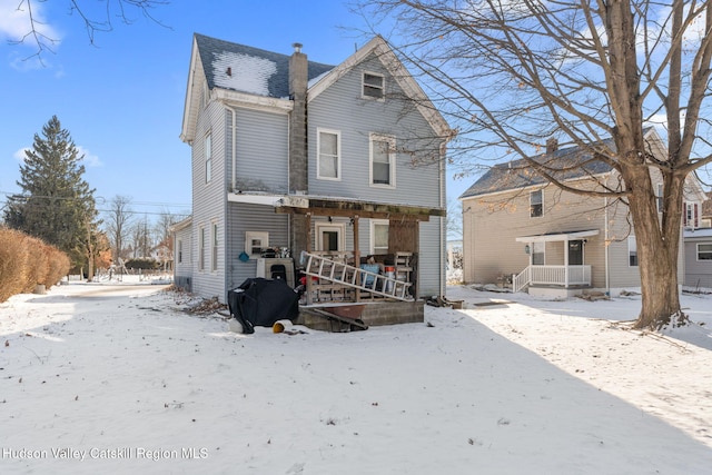 view of snow covered back of property