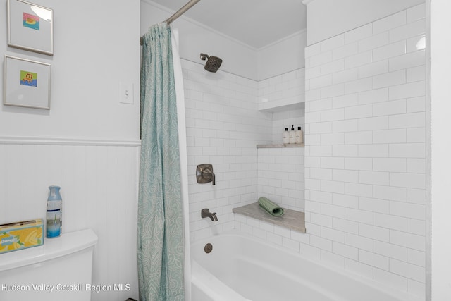 bathroom with toilet, shower / bath combo, and wainscoting