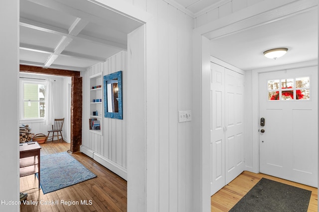 entrance foyer featuring a baseboard radiator, light wood-style flooring, beam ceiling, and coffered ceiling