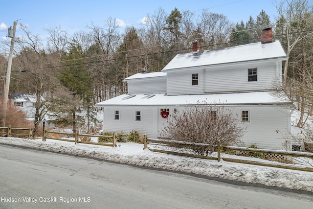 view of front of home featuring a chimney and fence