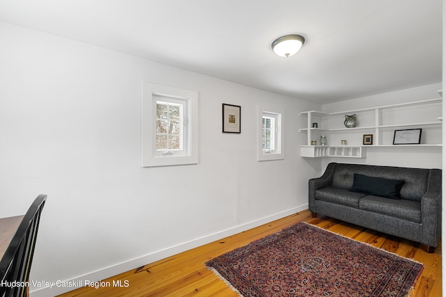 living area with baseboards and wood finished floors