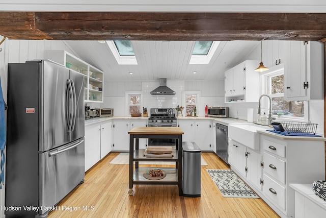 kitchen featuring stainless steel appliances, white cabinets, light countertops, and hanging light fixtures