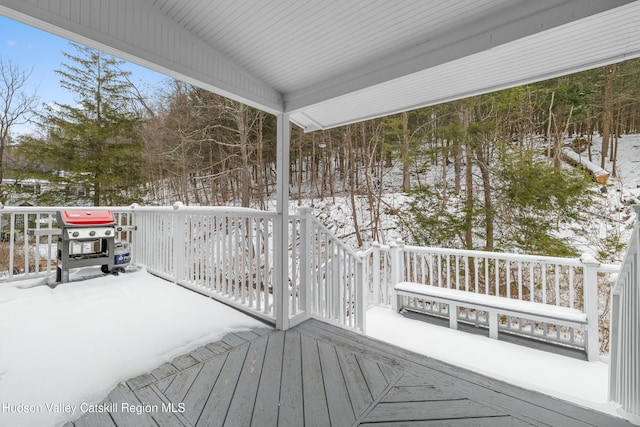 snow covered deck with a grill